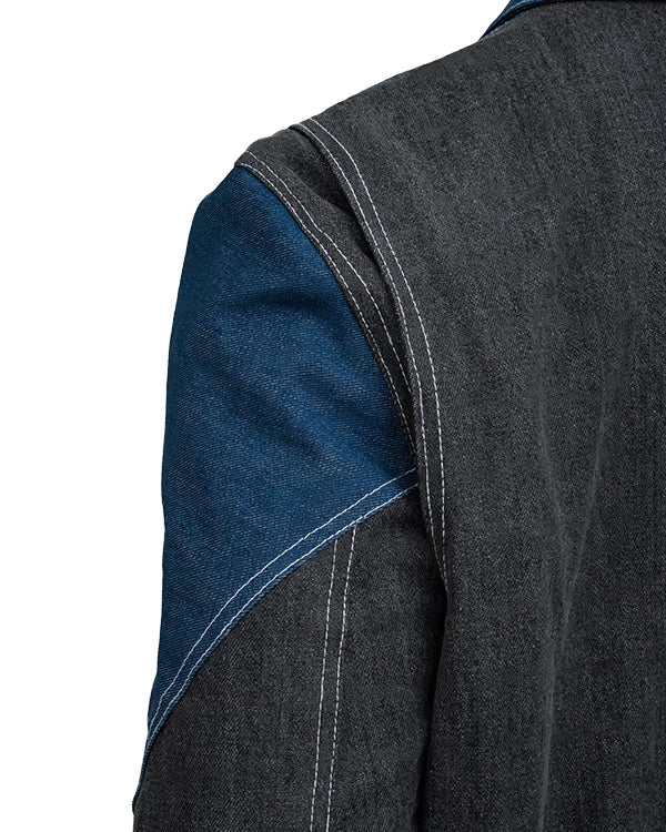 Close-up of a dark denim jacket with blue arm panel on a white background