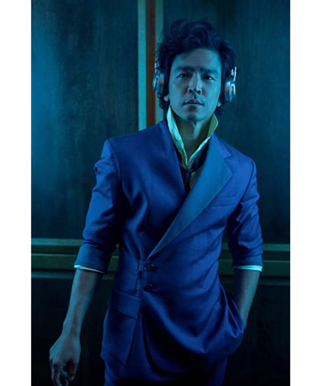 Person wearing a blue suit with a dark background